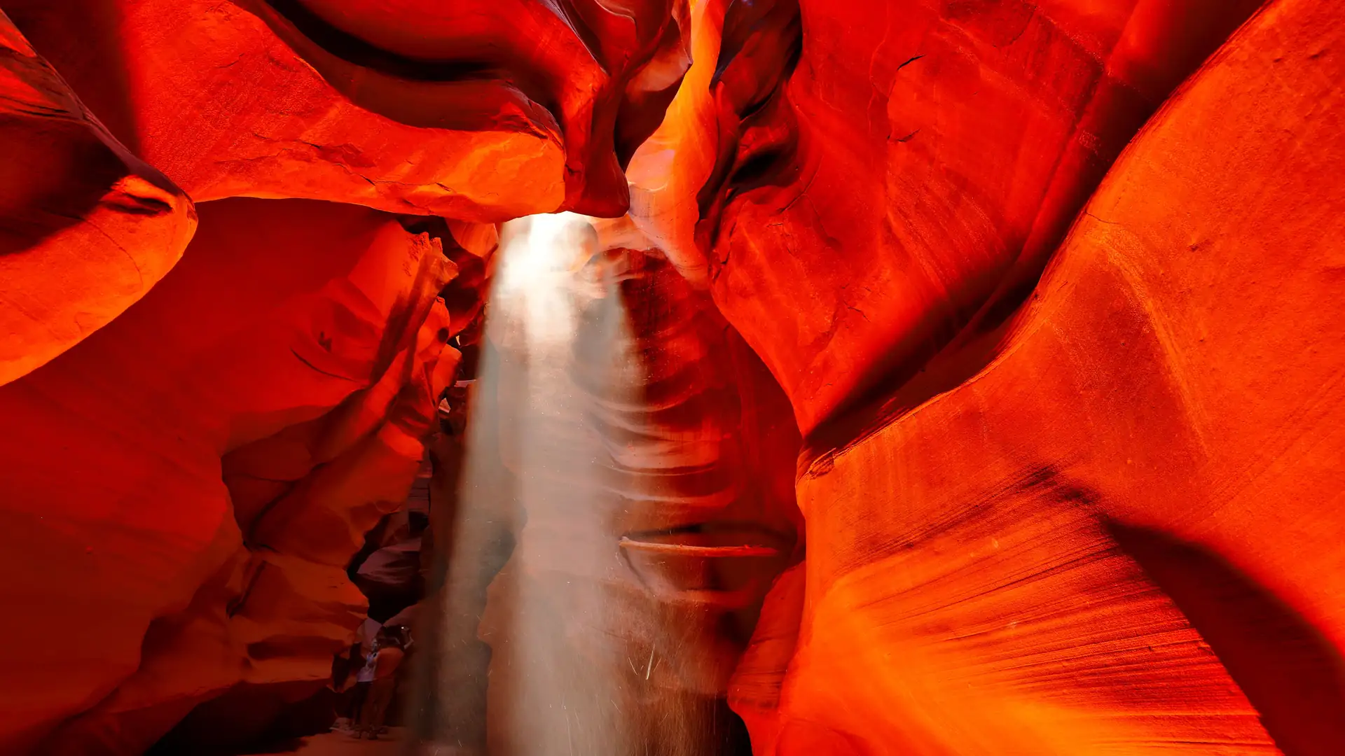 A shaft of sunlight falling through the glowing red sandstone walls of Antelope Canyon